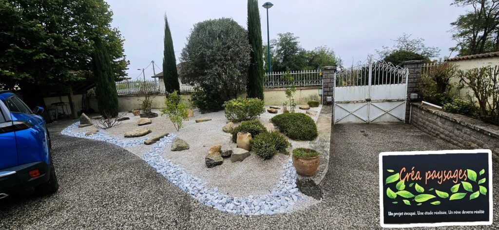 Aménagement paysager entrée : jardin graviers et rocaille. Entrée paysagère moderne avec jardin sec en graviers blancs et rocaille près d'une allée et d'un portail blanc. Plaque Créa paysages.